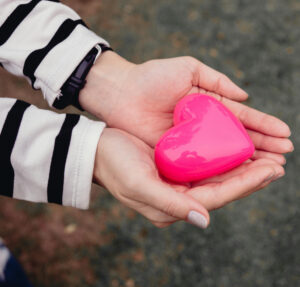 Hands Holding a Heart Shaped Toy